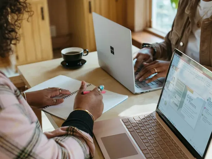 Two people collaborating with laptops and notes at a table, as CityBiz Ratings helps users find trusted local pros